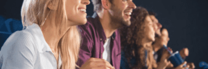 man and woman eating popcorn in movie theater